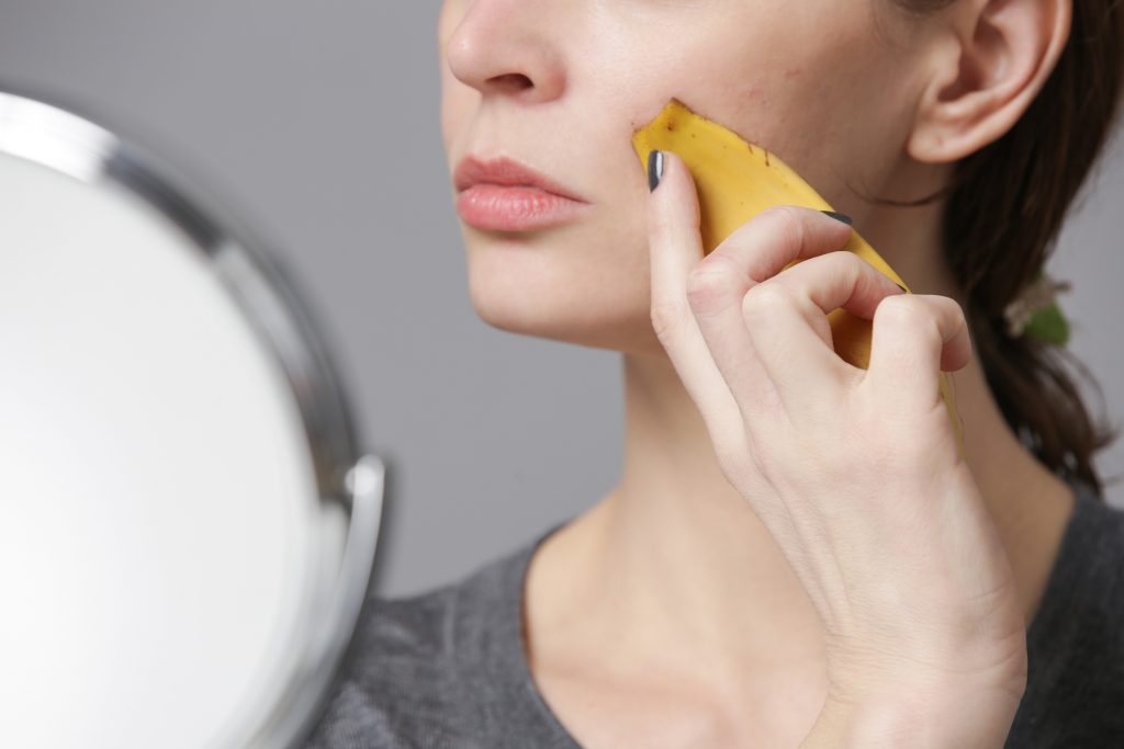 Une femme utilisant de la peau de banane sur son visage