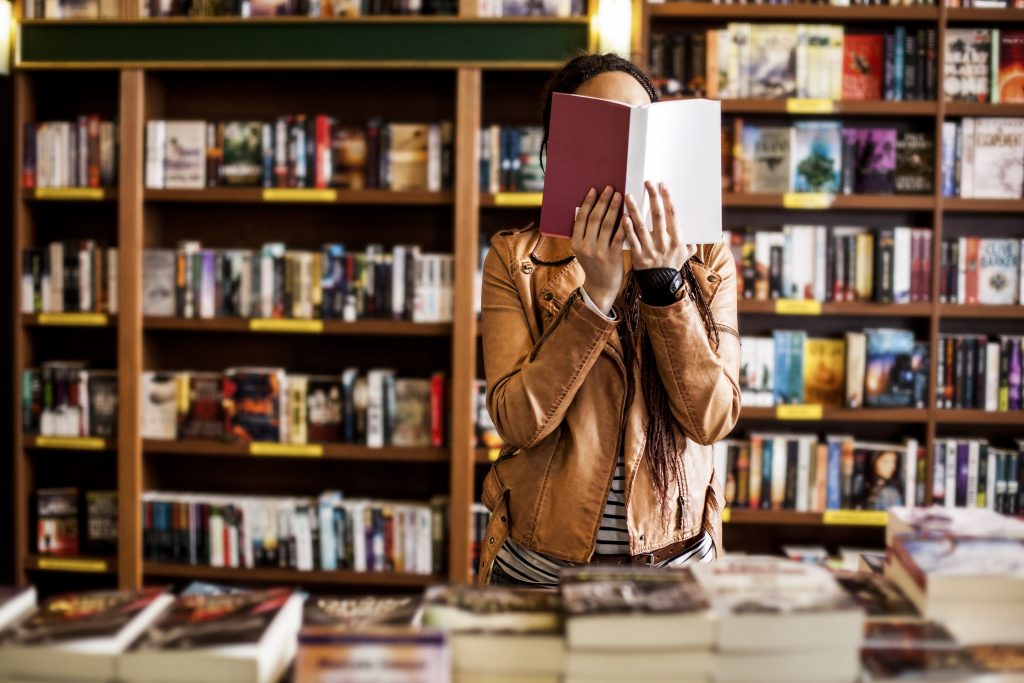Une personne tenant un livre dans une bibliothèque
