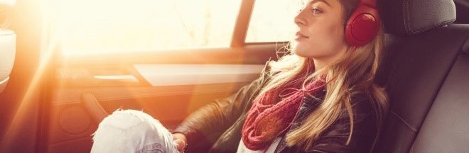 Podcast-série-cinema-a-ecouter fille avec un écouteur assis dans une voiture