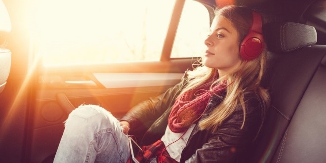 fille avec un écouteur assis dans une voiture