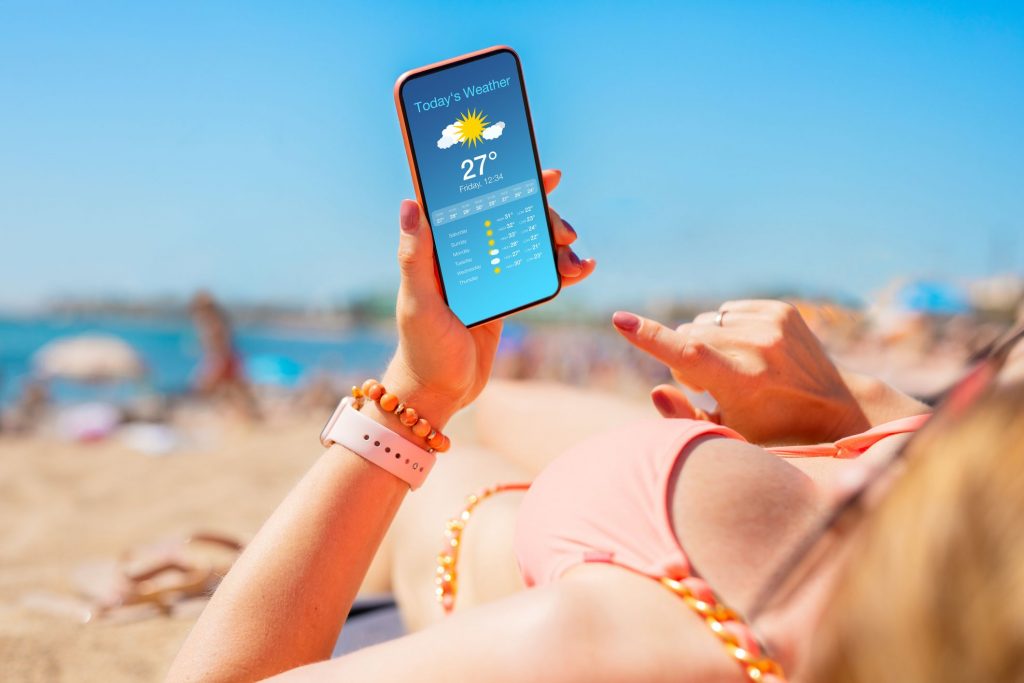 Femme sur la plage tenant un smartphone