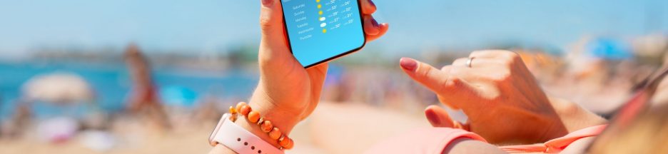 Femme sur la plage tenant un smartphone