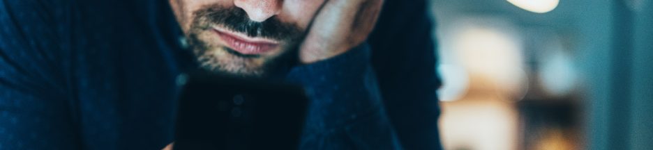 Temps-passe-reseaux-sociaux-chez-les-jeunes Un homme fixant l’écran de son smartphone