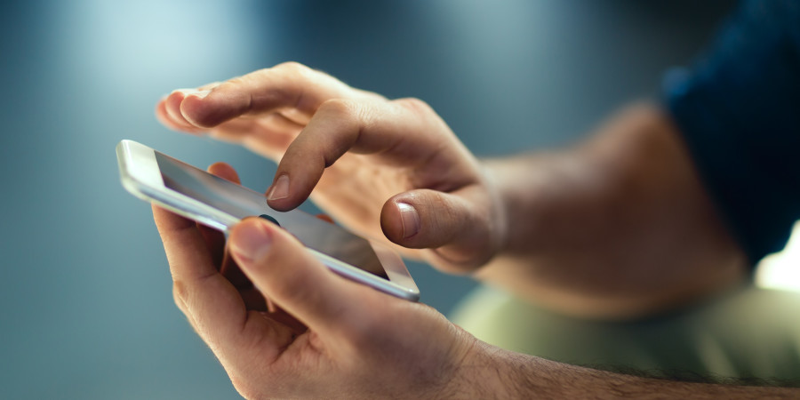 Un adulte en train de manipuler un petit smartphone dans le cadre d’un contrôle parental.