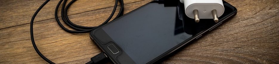 Un smartphone avec son chargeur qui aurait bien besoin d’une solution d’alimentation back up en cas de coupure d’électricité.