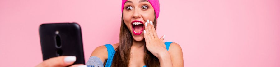 mascara-wand-tiktok Une utilisatrice de TikTok, smartphone à la main, s’excitant d’une publication avec le hashtag « Mascara wand »