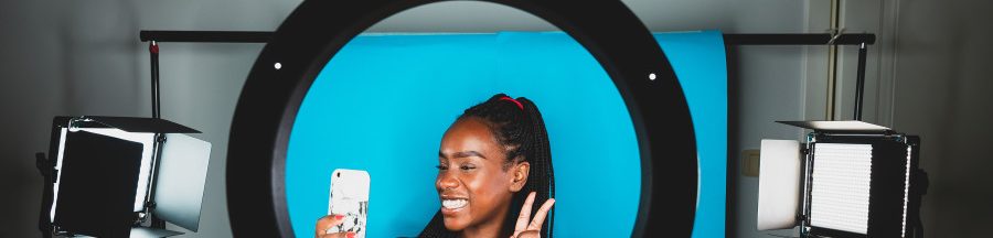 desinfluence-phenomene-tiktok-lutter-contre-surconsommation Une désinfluenceuse dans un studio d’enregistrement avec son smartphone à la main