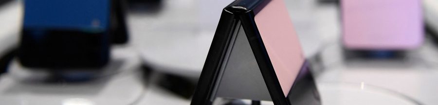 smartphones-pliables-5g-histoire-telephonie-mobile Des smartphones pliables présentés dans une vitrine de boutique de téléphonie mobile.