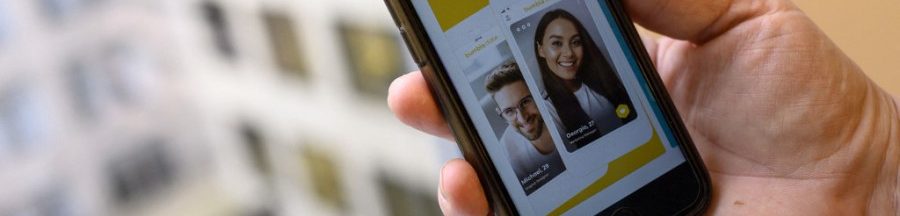 beige-flag-tikok-profil-ennuyant-annecdotes-applications-rencontre Une personne tenant son smartphone, en train de consulter le profil de rencontre deux personnes pour voir s’ils sont taxés « beige flag ».