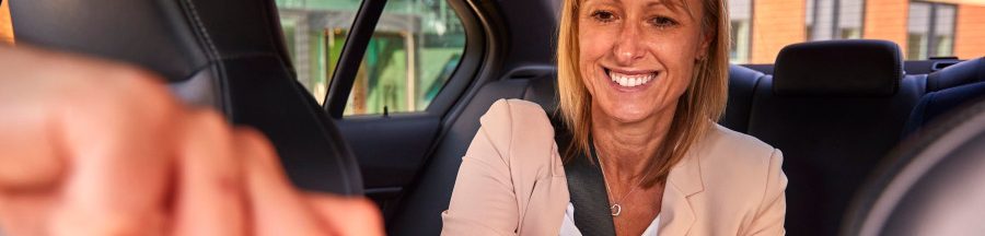 Une femme dans une auto testant les nouvelles fonctionnalités offertes par la technologie sans contact.