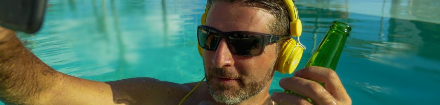 surchauffe-smartphone-canicule-gestes-protection Un homme se relaxant dans une piscine, exposant son téléphone au soleil et ignorant les gestes pour éviter une surchauffe de smartphone.