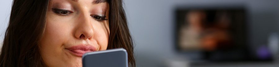 arnaque-a-l-iphone-15-vol-de-donnees Une femme fixe son smartphone. Une offre en ligne la laisse sceptique. Elle se doute bien qu’il s’agit d’une arnaque à l’iPhone 15.