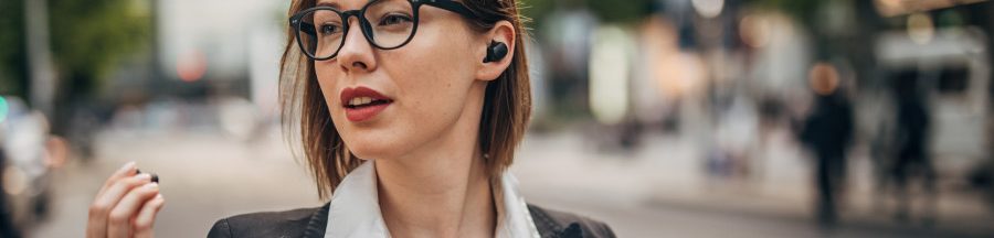Une femme dans la rue utilisant les Pixels Buds de Google, qui compte lancer une fonction de protection auditive sur Android 14.