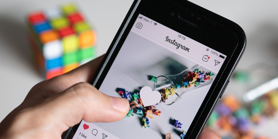 Une personne en train de liker un contenu partagé sur les réseaux sociaux Facebook et Instagram.