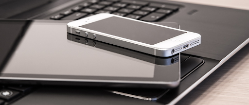 Un smartphone et une tablette posés sur le clavier d’un ordinateur portable. Un smartphone et une tablette posés sur le clavier d’un ordinateur portable.
