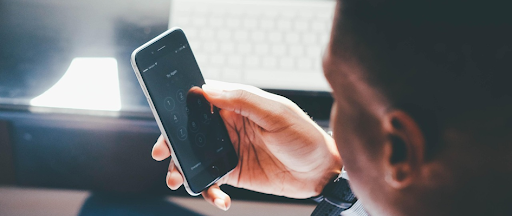 Une homme assis à son bureau, tenant son smartphone dans sa main. Une homme assis à son bureau, tenant son smartphone dans sa main.