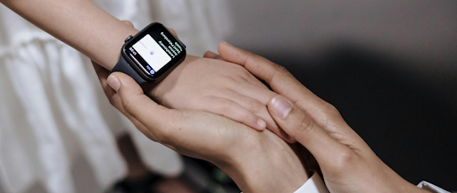Une main d’enfant portant une smartwatch, tenant les mains d’un adulte. Une main d’enfant portant une smartwatch, tenant les mains d’un adulte.