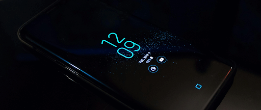 Smartphone Samsung Android noir allumé affichant l'horloge à 12:09.
