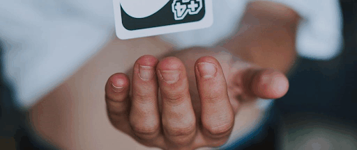 Un homme faisant léviter une carte d’UNO 4+. Un homme faisant léviter une carte d’UNO 4+.