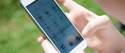 Une personne tenant un smartphone avec l’application de jeu Pokémon GO ouverte. Une personne tenant un smartphone avec l’application de jeu Pokémon GO ouverte.