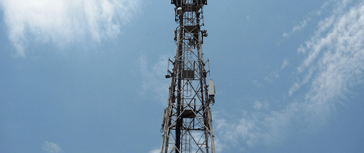 Une tour de télécommunications sous un ciel azuré.