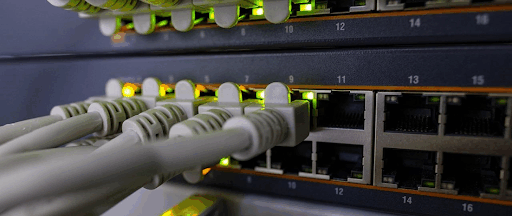 De multiples câbles Ethernet de couleur blanche connectés à un routeur Internet.