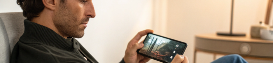 un homme qui regarde un film préquel sur son smartphone