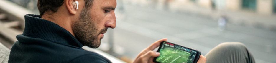 un homme qui regarde un match de football sur son smartphone