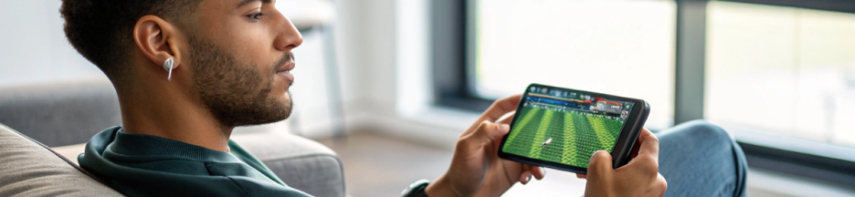 un jeune homme qui suit la Premier League sur son smartphone