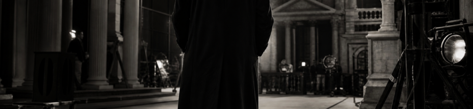 Acteur britannique de dos en long manteau sombre
