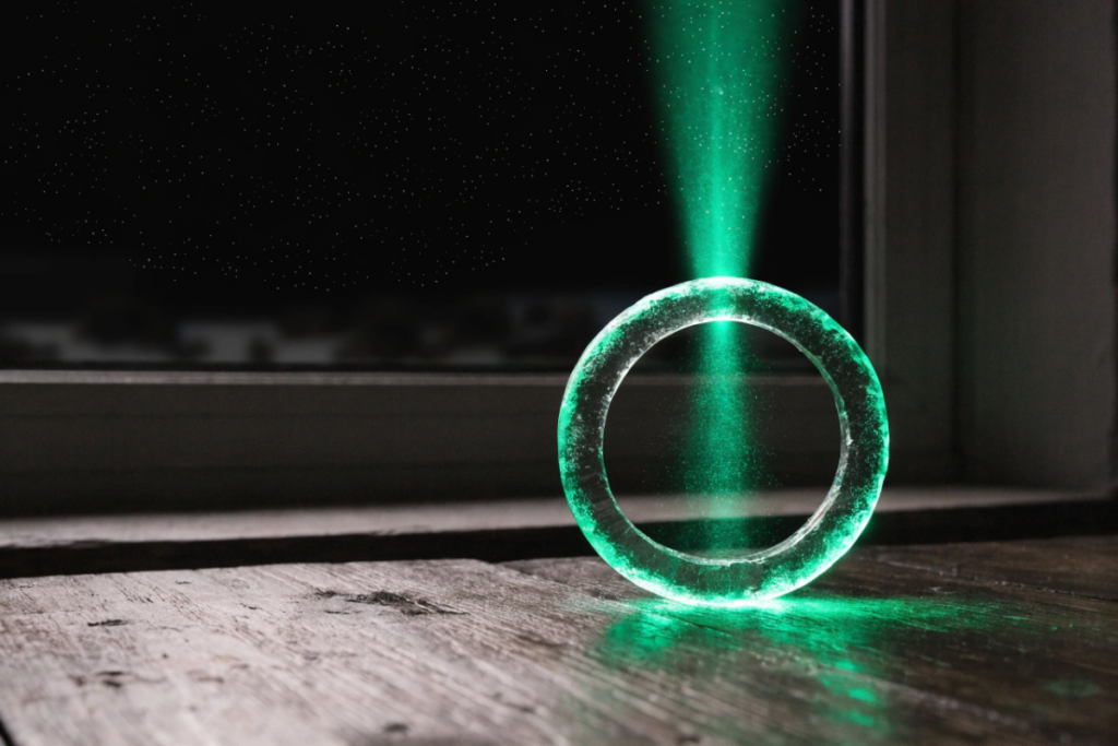 Un anneau vert lumineux projetant un faisceau vers un ciel étoilé