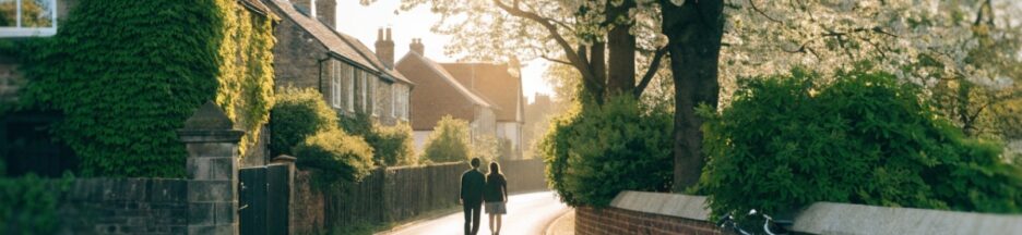 Silhouettes de dos marchent côte à côte dans une rue fleurie