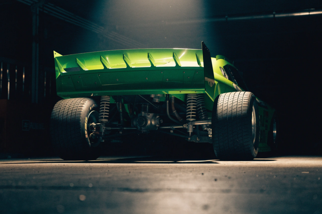 voiture de NASCAR vert fluo dans un garage sombre évoquant le film Days of Thunder 2