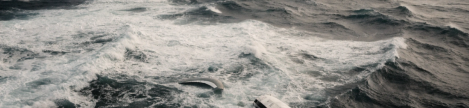 Débris d'un avion flottant au loin sur un océan agité