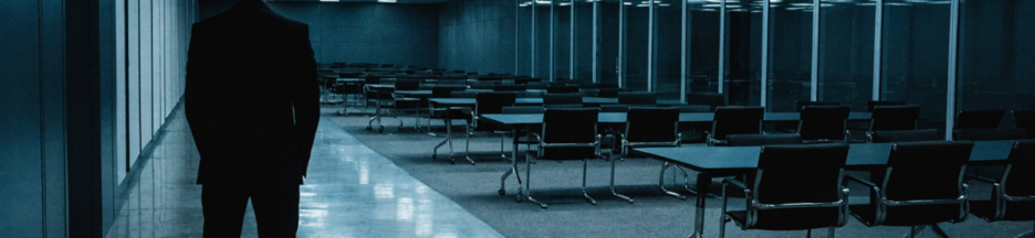 Silhouette d'un homme dans une immense salle de conférence évoquant Jeremy Strong
