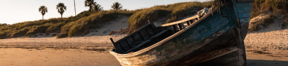 Bateau échoué sur une plage sauvage au coucher du soleil