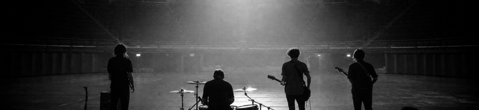 Un groupe de rock de dos sur une immense scène vide