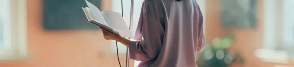 une chanteuse anonyme de dos avec un carnet devant un microphone évoquant Adèle Castillon