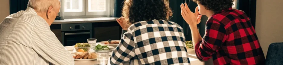 Père âgé et enfants adultes réunis autour d'une table évoquant Claude