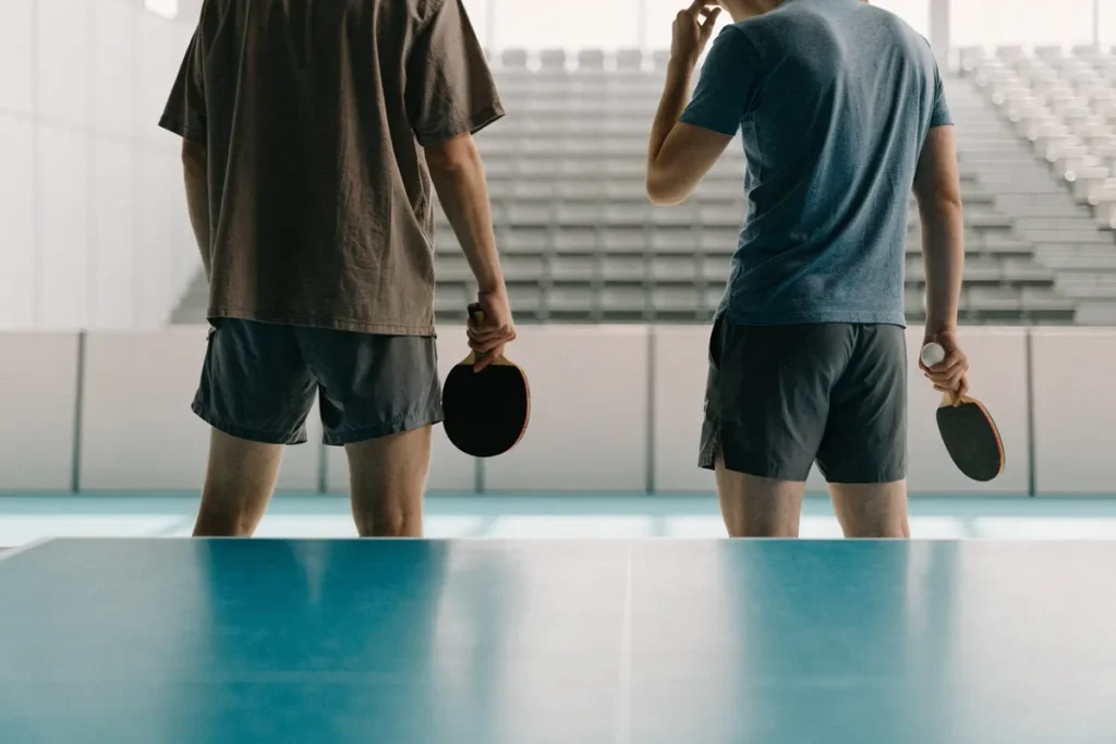 Deux sportifs devant une table de ping-pong évoquant Félix Lebrun et Alexis