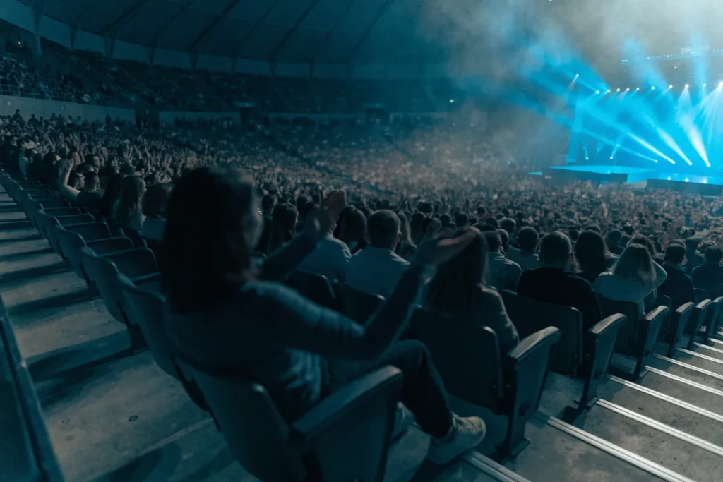 Des spectateurs dans une arena avant un concert évoquant l’ambiance de concert de Toto