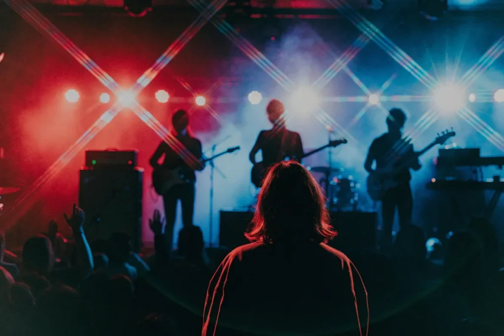 Silhouette d’une jeune femme devant une scène rock énergique évoquant les contrastes sonores du mini-album IMPULSE